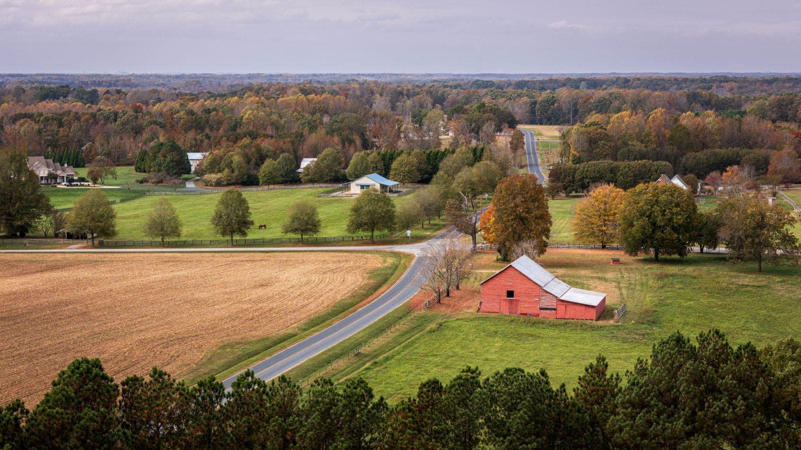 Byron Center chimney sweep service area: farm fields and a red barn along a country road